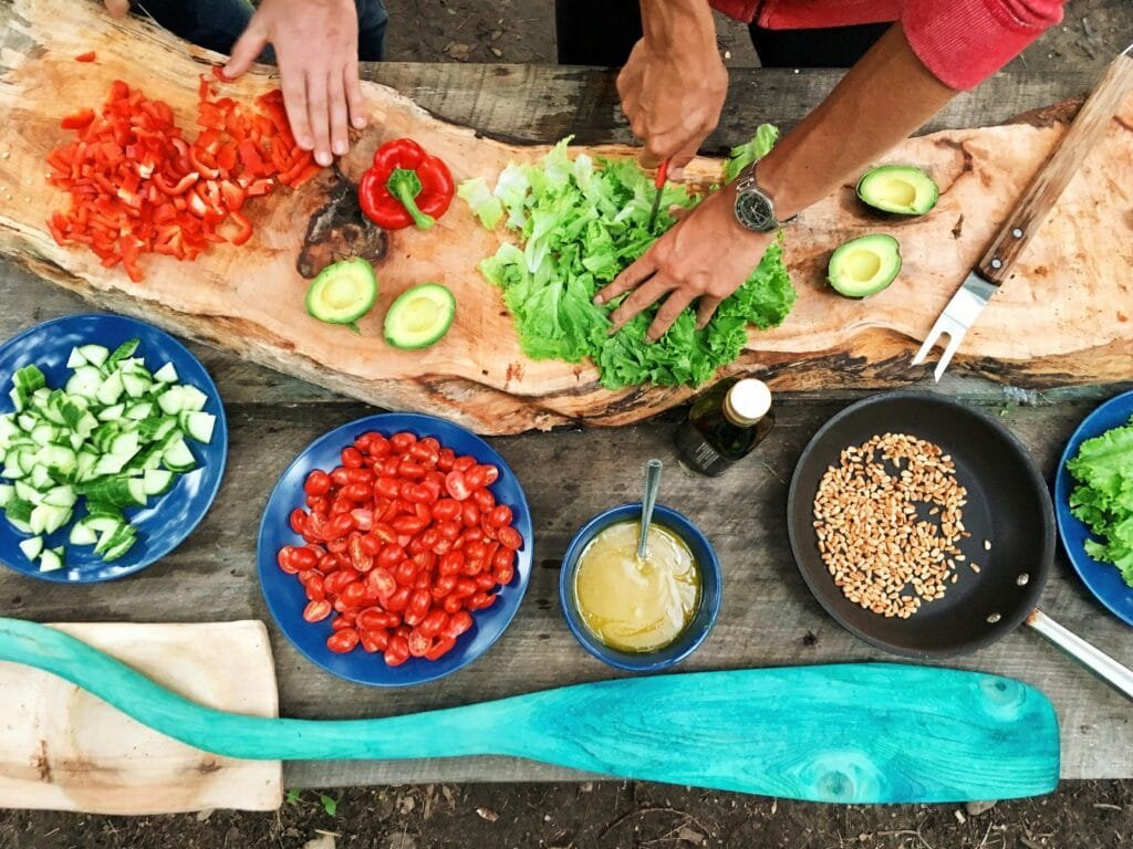 Stress Management Techniques to Improve Your Life Fresh ingredients being prepared on a rustic wooden table, showcasing vibrant vegetables and hands at work.