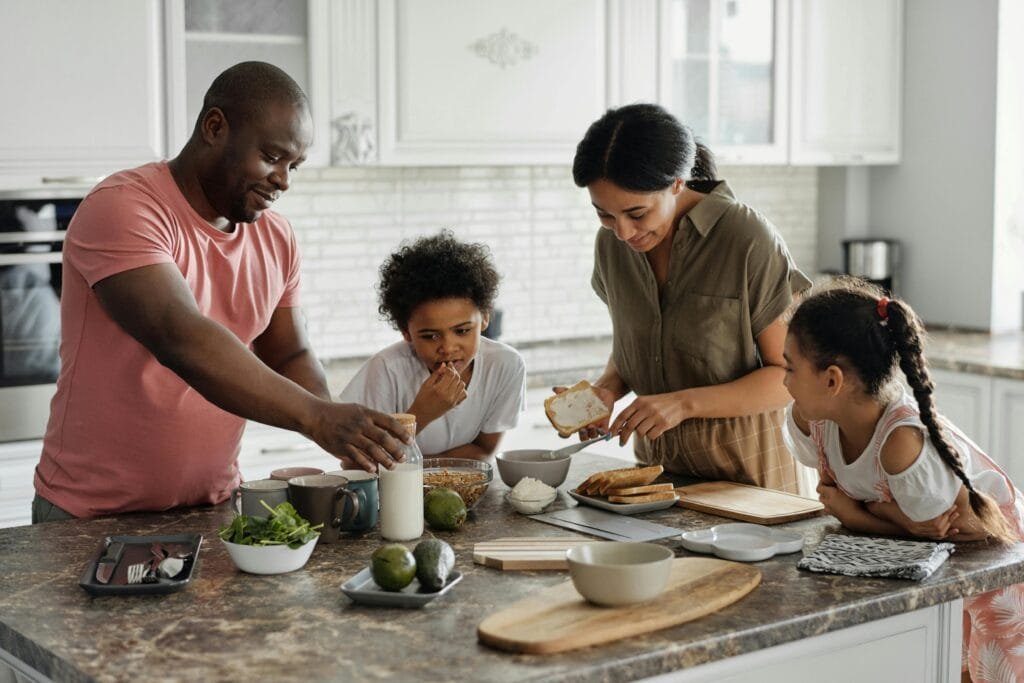 Finding Balance: Navigating Relationships & Personal Growth A joyful family enjoys preparing a healthy meal together in their modern kitchen.